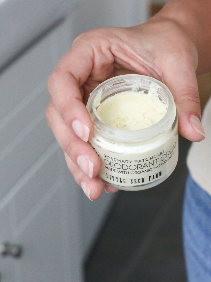 Hand holding jar of Rosemary Patchouli natural deodorant cream