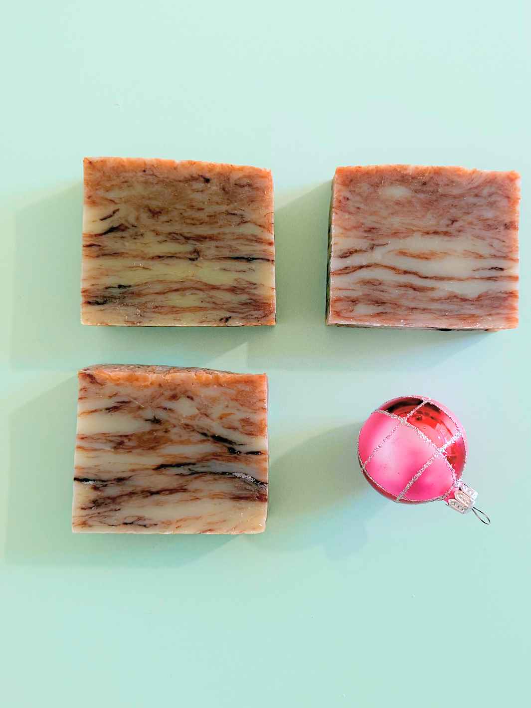 Cocoa Mint Bath Soap on a green background with a pink and red vintage Christmas ornament