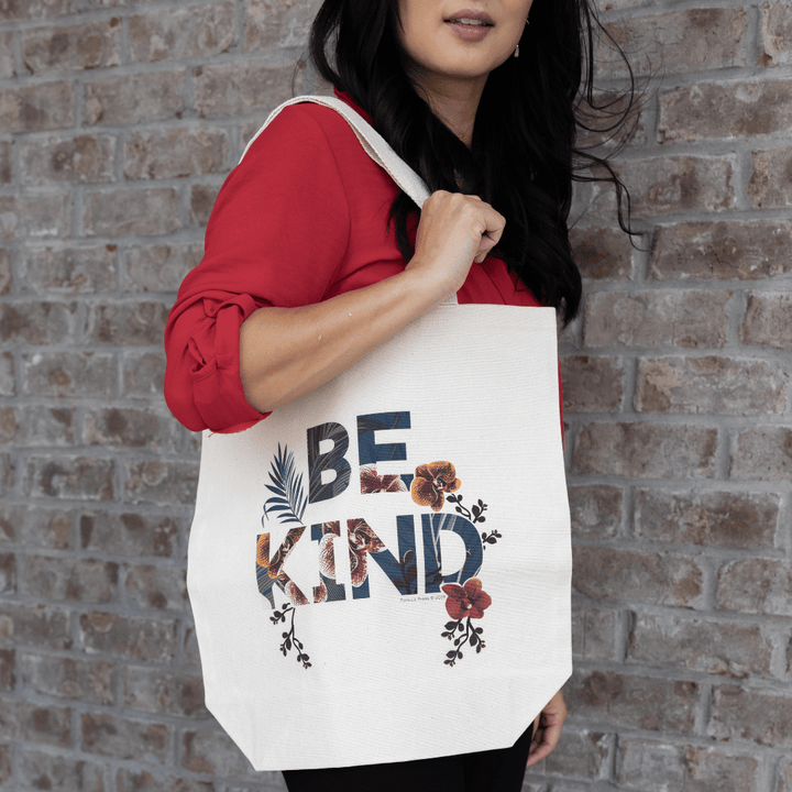 Asian woman wearing red shirt carrying a Good Soul Shop canvas tote bag that says Be Kind.